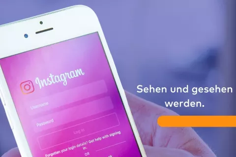 Auf einem Smartphone-Bildschirm ist die App Instagram zu sehen und neben dem Bild steht der Text: Sehen und gesehen werden.